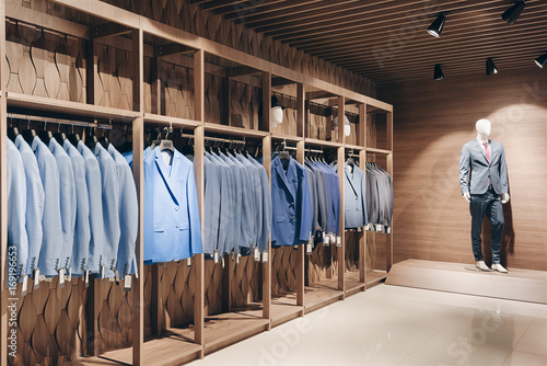 Hangers with business suits in a row in the interior of a business suit shop and expensive premium clothes.