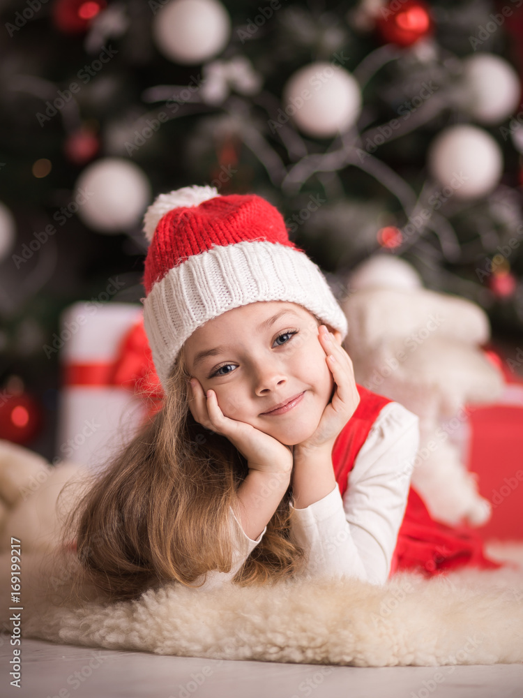 Portrait of a cute little girl on a christmas tree background. Portrait of a cute little girl on a christmas tree background.