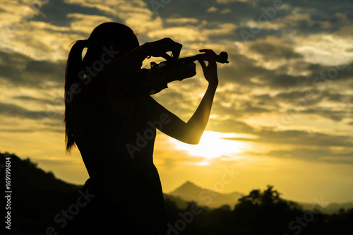 silhouette Violin woman player on sunset background
