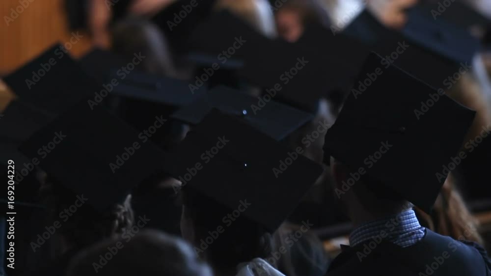 Group of students in academic dress waiting for graduation ceremony in hall Group of students in academic dress waiting for graduation ceremony in hall