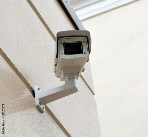 Security camera on the wall of an office building in the city, technology