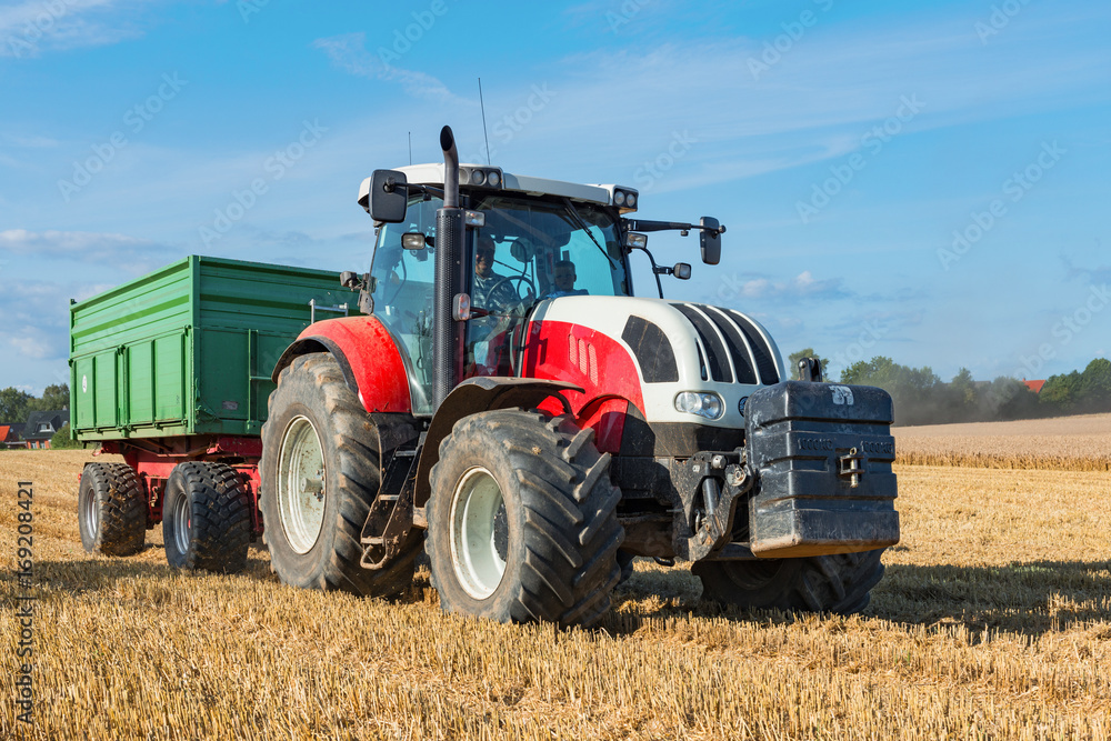 Fototapeta premium Tractor with trailer at the grain harvest in the field - 6643
