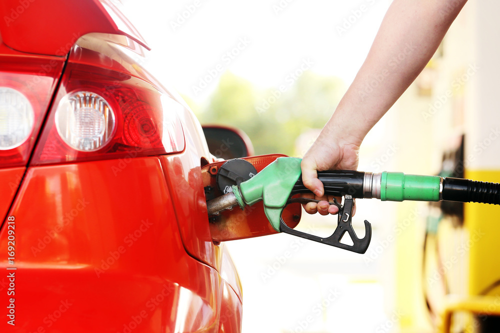 Refueling red car at the refuel station Refueling red car at the refuel station