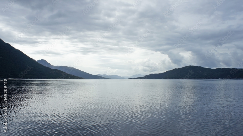Silhouette of mountains, view from the ferry, cloudy weather, Norway, Scandinavian landscape