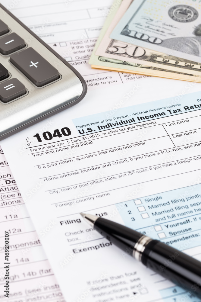 Tax form with calculator, pen, and dollar banknote Tax form with calculator, pen, and dollar banknote