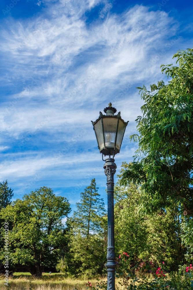 Old street lantern in the park at sunshine and blue sky