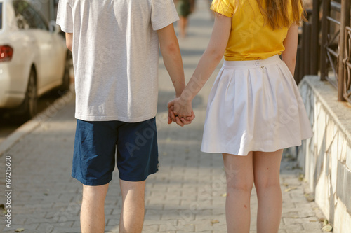Obraz na płótnie Beautiful Young couple  walk hand in hand on the road