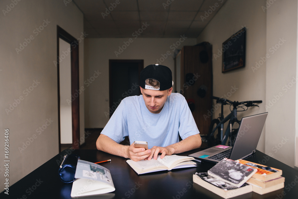 A young student uses a telephone while studying. Teaching at home. A young student uses a telephone while studying. Teaching at home.