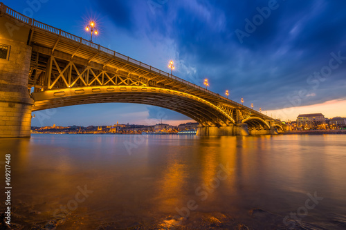 Budapest, Hungary - A beautiful colorful sunset and clouds at the Margaret Bridge taken from Margaret Island at dusk with Szechenyi Chain Bridge and Buda Castle at background © zgphotography