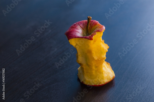 a apple core eaten on a black table
