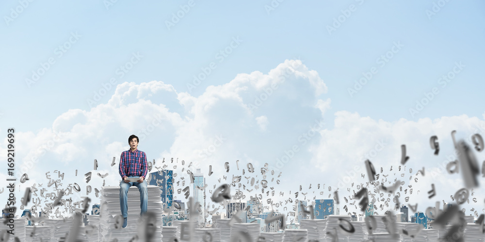 Attractive man sitting on pile of paper documents. Attractive man sitting on pile of paper documents.