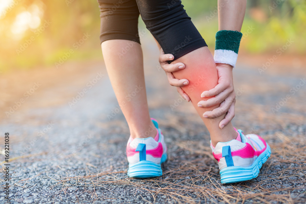 Running sport injury . Female athlete runner touching foot in pain due.