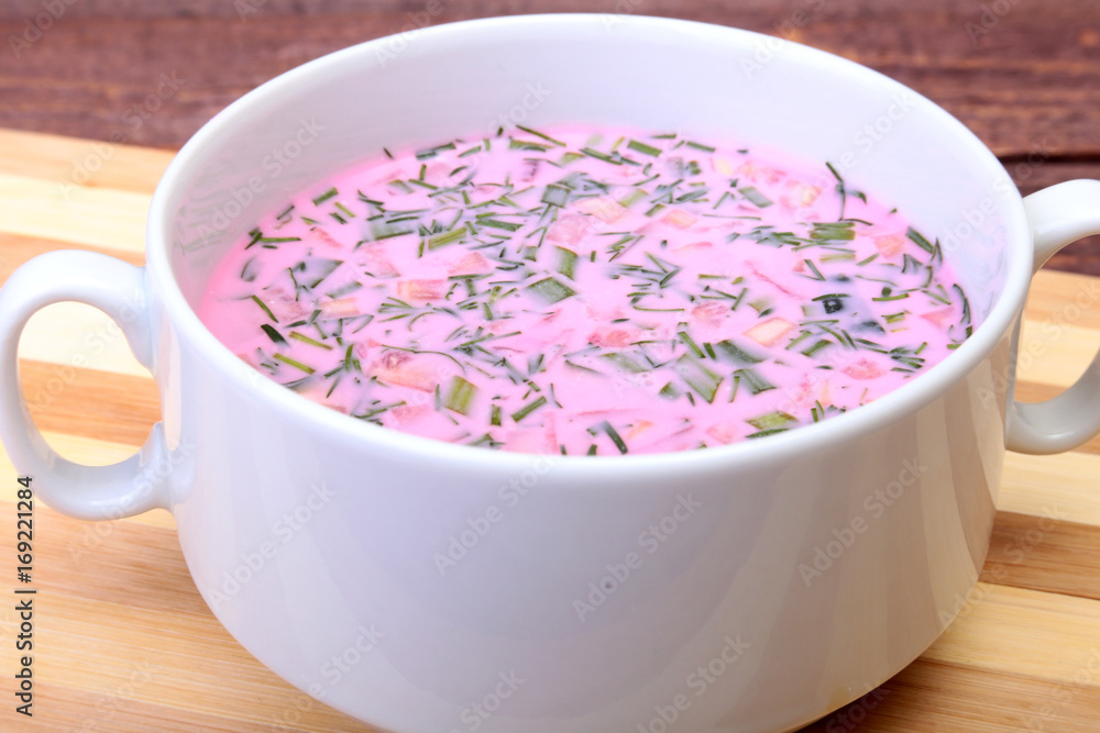 Popular spring cold soup okroshka with yoghurt. Okroshka in a bowl on wooden table. Selective focus Popular spring cold soup okroshka with yoghurt. Okroshka in a bowl on wooden table. Selective focus