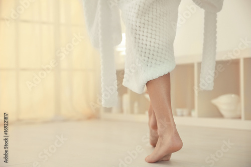 Young woman walking on floor after shower