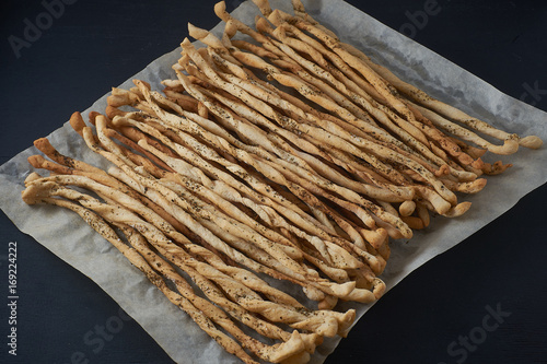 Traditional Italian snack, bread - grissini. On a dark stone table. photo