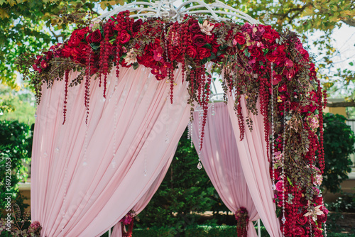 Декорации из красных цветов на свадебном торжестве