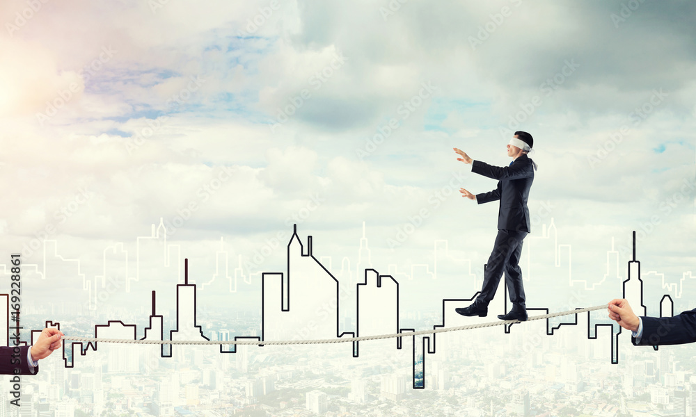 Business concept of risk support and assistance with man balancing on rope
