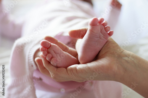 Pies de bebé recién nacido sobre la mano de su madre © Darina Evans