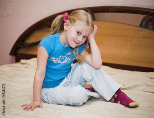 Little blonde girl on the bed