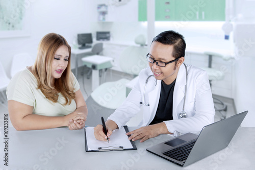 Male doctor writing a prescription to his patient