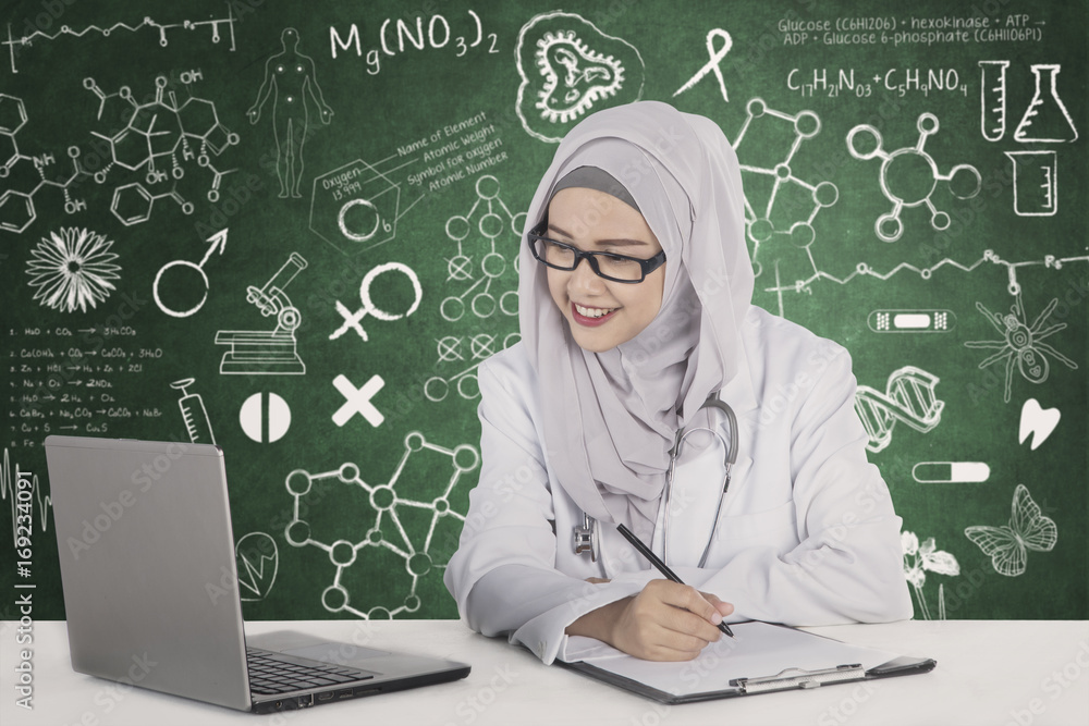 Muslim doctor with scribbles on the chalkboard Muslim doctor with scribbles on the chalkboard