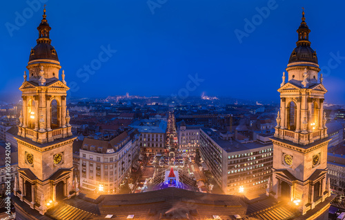 Budapest, Hungary - Panoramic skyline view of Budapest from Saint Stephens Basilica at blue hour at winter time with christmas market