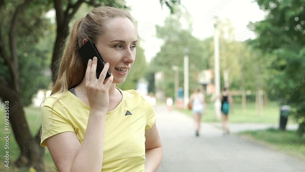 Sporty girl going round on pathway while speaking on cellphone, steadycam shot
Sporty girl going round on pathway while speaking on cellphone, steadycam shot