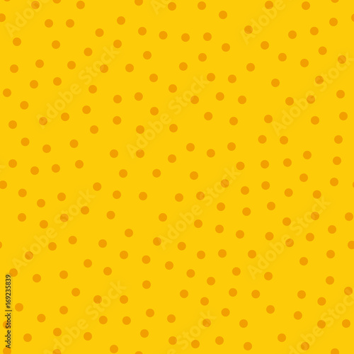 Orange polka dots seamless pattern on yellow background. Impressive classic orange polka dots textile pattern in restrained colours. Seamless scattered confetti fall chaotic decor.