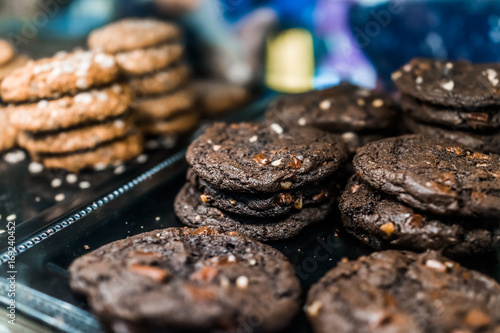 Macro closeup of dark fudge chocolate chip and nuts cookies on display in bakery