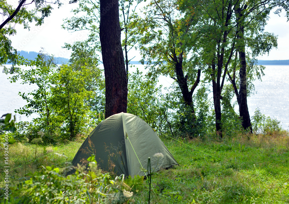 Camping tent on coast of lake.