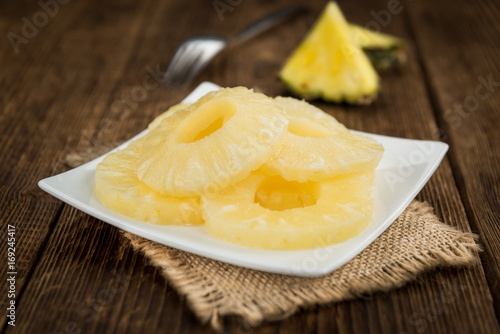 Portion of Preserved Pineapple Rings on wooden background, selective focus