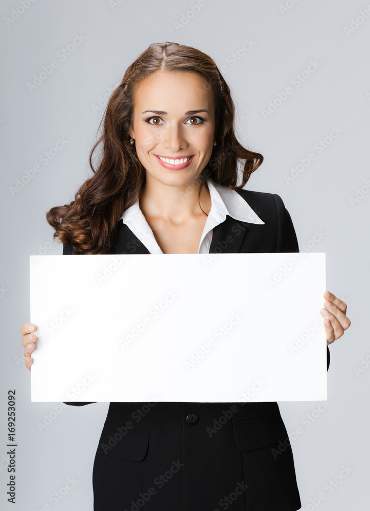 Businesswoman showing signboard, over grey