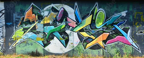 Obraz Stara ściana, pomalowana w kolorowe graffiti rysunek farbami w aerozolu. Obraz w tle na temat rysowania graffiti i sztuki ulicznej