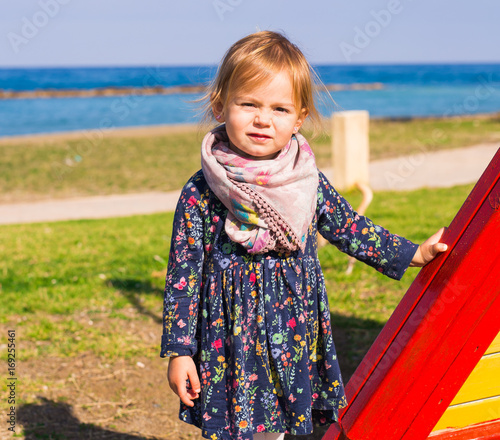 Portrait of beautiful young baby girl on the playground photo