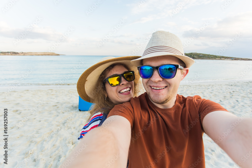 tourists couple taking selfie on the beach. Vacation, love, travel and holiday concept.