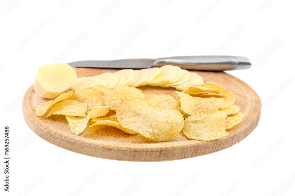 Cutting board with raw potato, potato chips and knife isolated on white background.