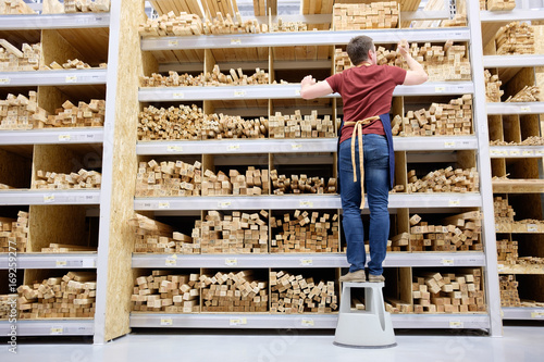 Konstfotografi worker or seller in construction store or warehouse wood section at work