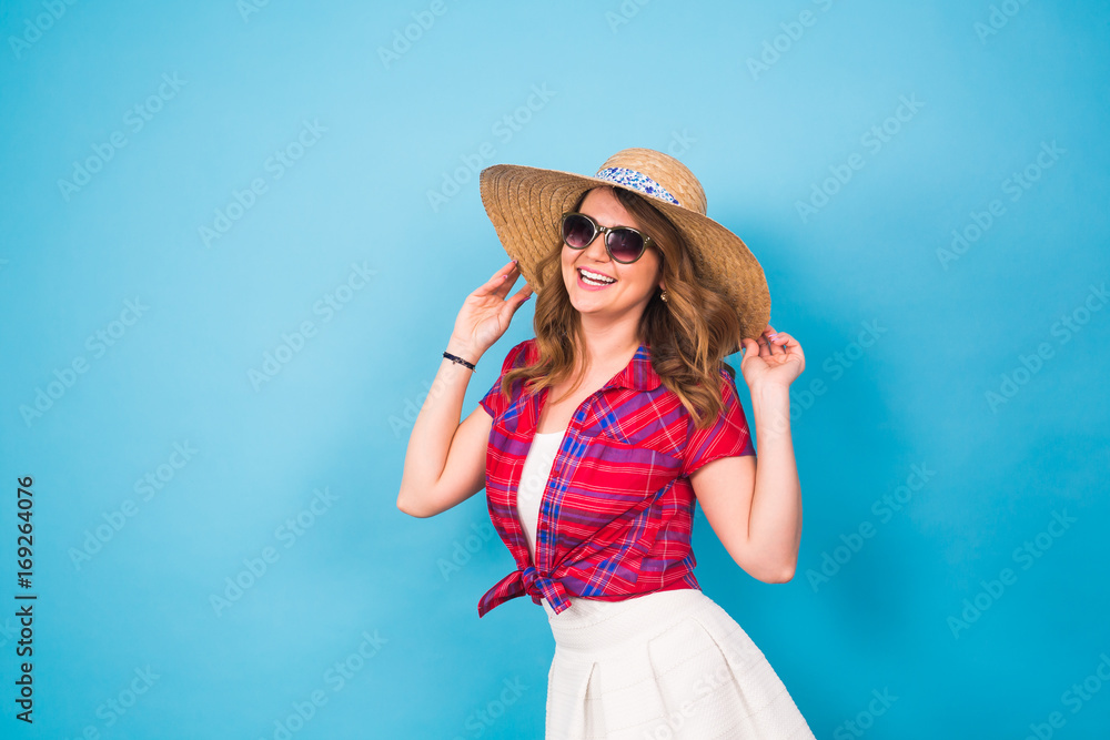 Holidays, summer, fashion and people concept - Girl in fashionable clothes straw hat. Portrait of charming woman on blue background with empty copy space Holidays, summer, fashion and people concept - Girl in fashionable clothes straw hat. Portrait of charming woman on blue background with empty copy space