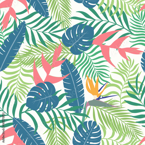 Tropical background with palm leaves and flowers. Seamless floral pattern