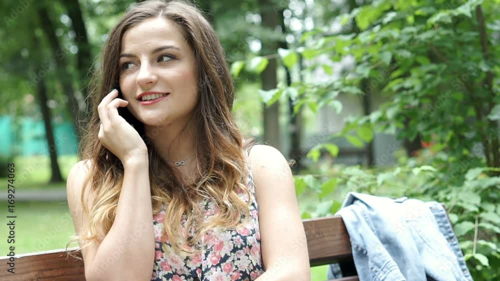 Pretty brunette sitting in the park and chatting on cellphone, steadycam shot
Pretty brunette sitting in the park and chatting on cellphone, steadycam shot