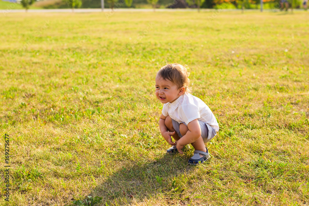 Portrait of cute little baby boy having fun outside. Smiling happy child playing outdoors Portrait of cute little baby boy having fun outside. Smiling happy child playing outdoors