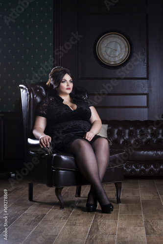 Plus size model, fat woman in black evening dress
