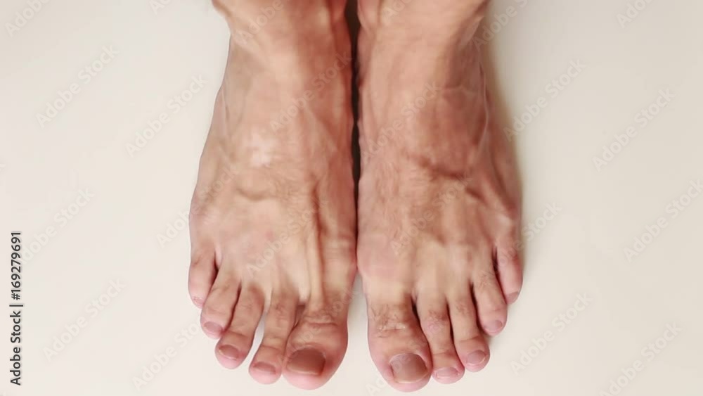 Man standing barefoot on white surface Man standing barefoot on white surface