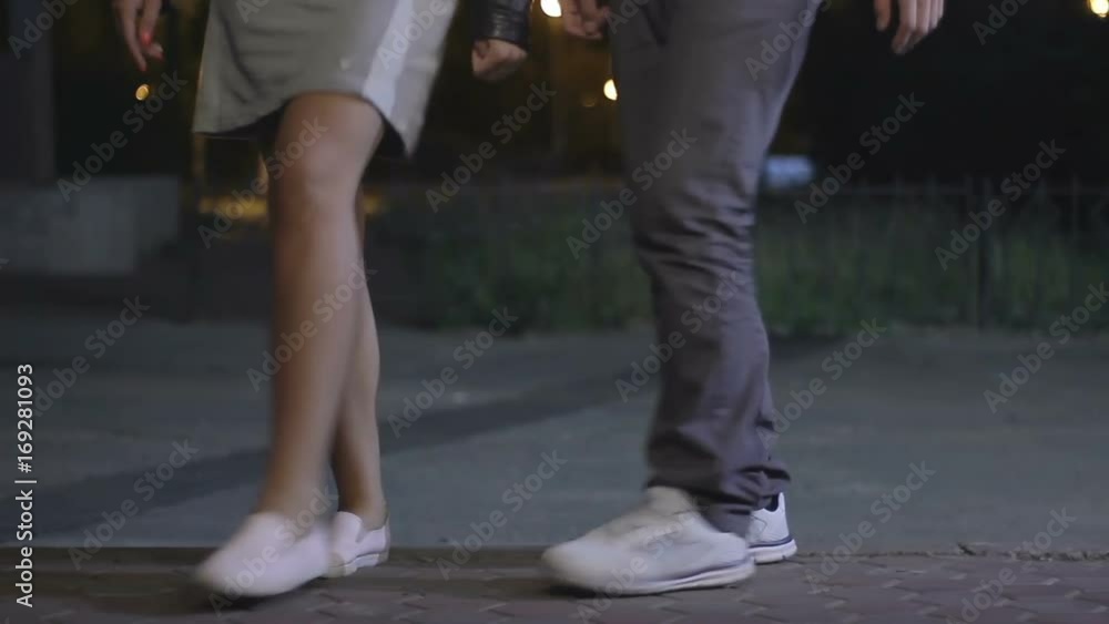Man and woman happily move to rhythm. Teenagers have fun at night in the park. a girl and a guy dancing