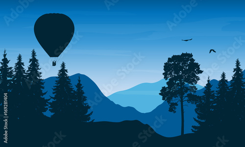 Vector illustration of a mountain landscape with a flying hot air balloon with people in a basket and birds