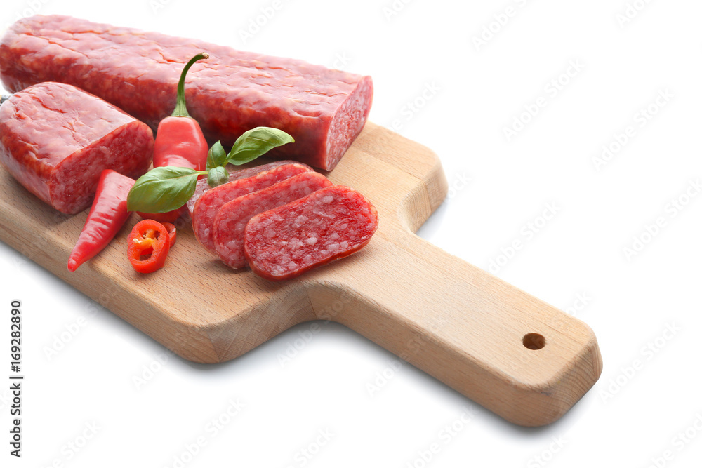 Wooden board with delicious sliced sausage and chili pepper on white background