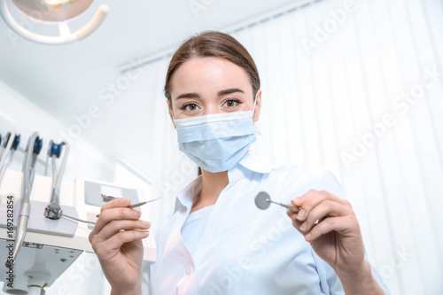 Young female dentist with tools in clinic