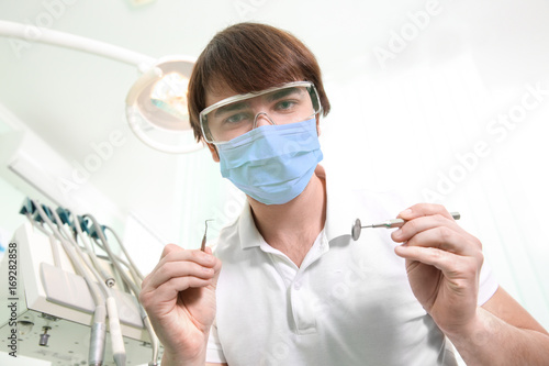 Male dentist with tools in ...