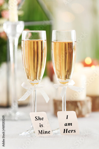 Beautiful composition with glasses of champagne and cards on table served for lesbian wedding