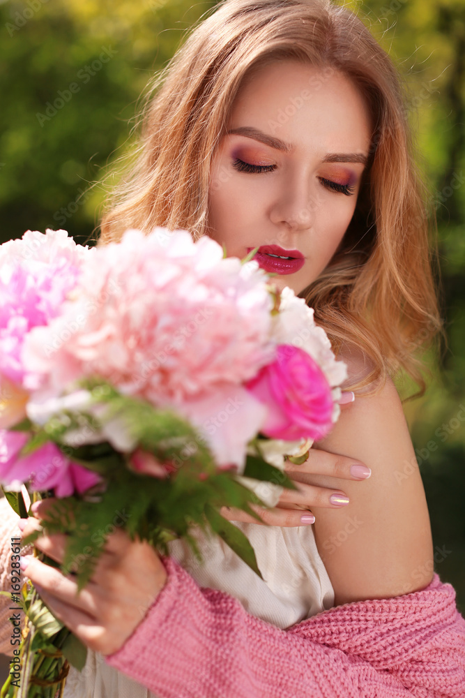 Fototapeta premium Beautiful young woman with bouquet of peonies, closeup